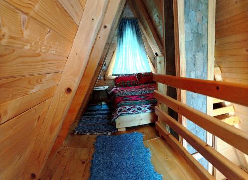 a small room with a bed and a window at M&K chalets in Žabljak