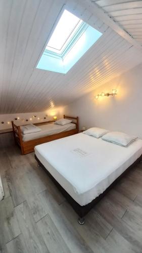 une chambre avec deux lits et une lucarne dans l'établissement Royan - Agréable Duplex Plage de Nauzan, à Vaux-sur-Mer