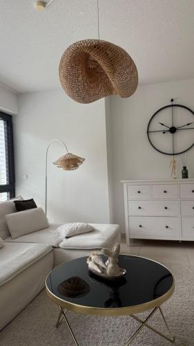 a living room with a couch and a table and a clock at PureNature Appartement in Obersontheim