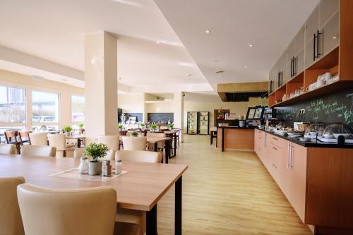 a restaurant with a table and chairs and a counter at REGIOHOTEL Leipzig West in Schkeuditz