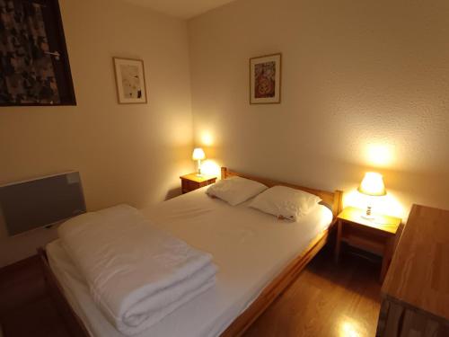 une chambre avec un lit avec deux lampes sur deux tables dans l'établissement Appartement skis aux pieds 6 pers, balcon, animaux admis - FR-1-445-99, à Montgenèvre