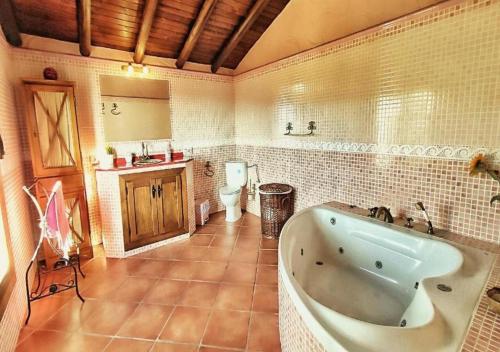 a large bathroom with a tub and a toilet at Villa 10 by Villamya in El Gastor