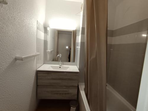 une salle de bain avec un lavabo, un miroir et une baignoire dans l'établissement Appartement skis aux pieds 6 pers, balcon, animaux admis - FR-1-445-99, à Montgenèvre