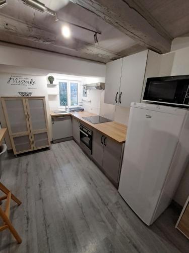 a kitchen with white cabinets and a white refrigerator at Magnifique F2 du bien être in Besançon