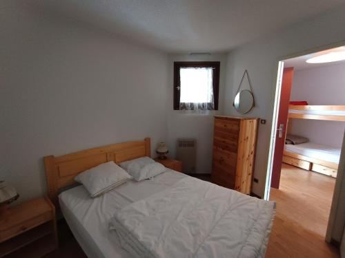 une chambre avec un lit, une commode et une fenêtre dans l'établissement Montgenèvre - Appartement sur les pistes 4-6 pers., balcon sud-ouest, animaux acceptés - FR-1-445-107, à Montgenèvre