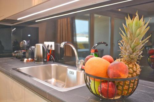 科孚镇Alykes Houses - Prv Jacuzzi的水槽旁的柜台上一篮水果