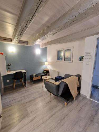 a living room with a couch and a table at Magnifique F2 du bien être in Besançon