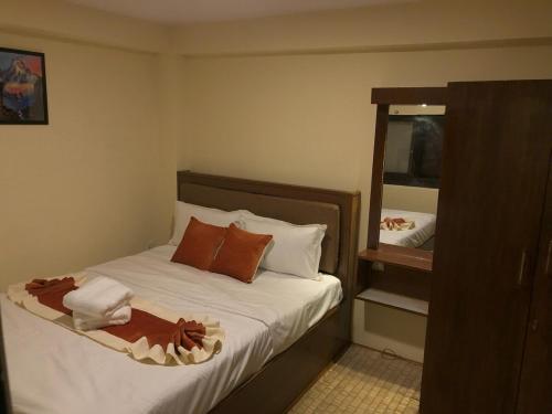 a small bedroom with a bed with a mirror at Zenith Apartments Thamel-Dhaulagiri 1BHK Apartment in Kathmandu