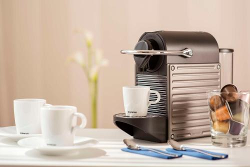 a toaster sitting on a table with a glass of coffee at NH Collection Wien Zentrum in Vienna