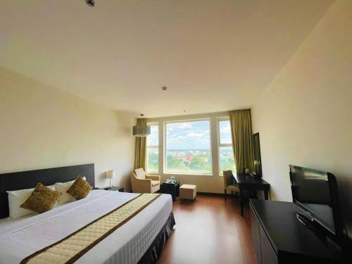 a hotel room with a bed and a large window at Sai Gon Ban Me Hotel in Buon Ma Thuot
