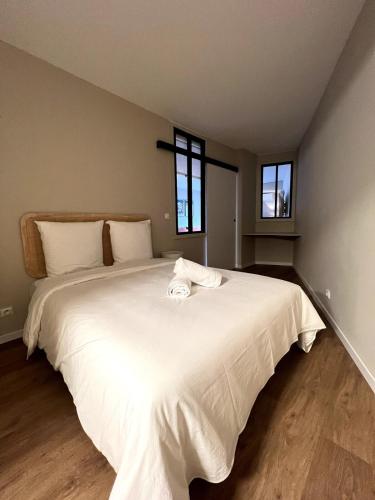- une chambre avec un grand lit blanc et 2 fenêtres dans l'établissement Apartment near Monaco, parking, à Beausoleil