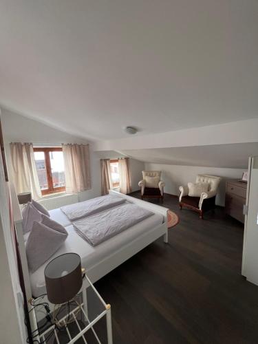 a bedroom with a large white bed and a chair at MaHome Apartments in Lofer