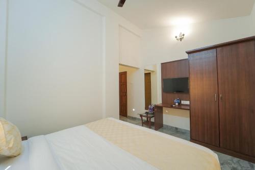 a bedroom with a large bed and a wooden cabinet at King Stone Villa in Panchgani