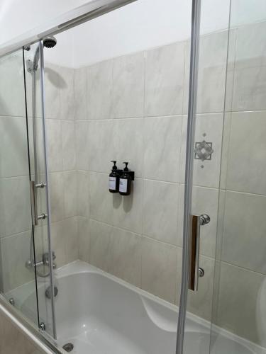 a shower with a glass door in a bathroom at Apt V in Praia