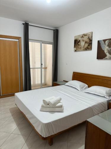 a bedroom with a bed with two towels on it at Apt V in Praia