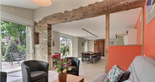 - un salon décloisonné avec une table et des chaises dans l'établissement Ô Pré des Fleurs, à Amanlis
