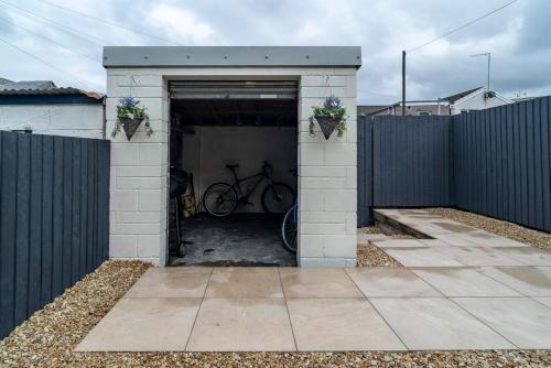 ein Fahrrad in einer Garage mit einem Zaun geparkt in der Unterkunft Ty Gwyrdd, 3 bedroom house, sleeps 7, Near Bike Park Wales in Abercanaid