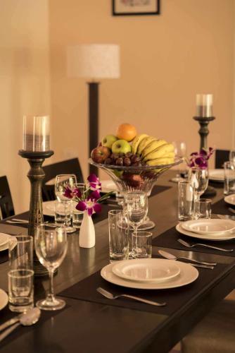 a dining table with a bowl of fruit and a centerpiece at Galleria: 4BHK Goan Villa with pool in Arpora in Goa