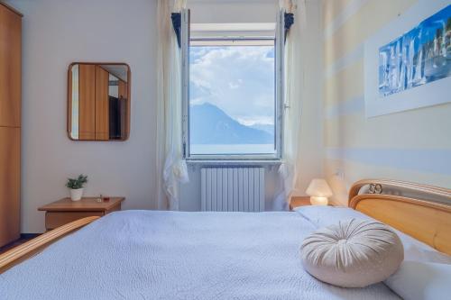 Un dormitorio con una cama grande con una ventana grande. en Candy House, en Varenna