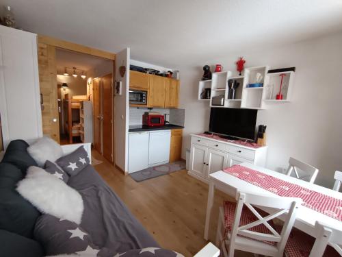 un salon avec un canapé et une table et une cuisine dans l'établissement Appartement rénové skis aux pieds 4 pers avec balcon - Parking inclus - FR-1-445-147, à Montgenèvre