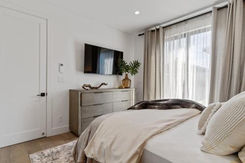 a bedroom with a bed and a tv and a window at Ocean Whispers home in Moss Beach