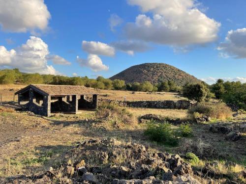 an old building in a field with a mountain in the background at Casa Annunziata - Bronte in Bronte