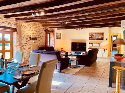 ein Wohnzimmer mit Tisch und Stühlen und einer Couch in der Unterkunft 4-Star Tourism Rated Holiday Home, 6 Bedrooms, with Air Con & Private Heated 10x4M Salt Water Pool - 40 Mins from Bergerac in Capdrot