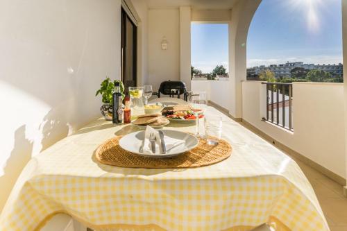 a table with a plate of food on a table at Bright Apartment 10min from 2 stunning Beaches in Olhos de Água
