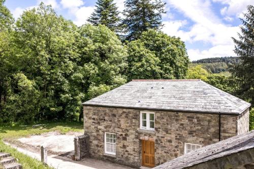 a stone house with a wooden door in a field at Glynn Bull Pen in Bodmin