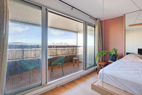 une chambre avec un lit et une grande fenêtre dans l'établissement Studio refait à neuf avec balcon et vue sur la Seine - bail mobilité, à Paris