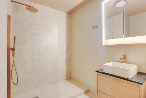 une salle de bain avec un lavabo et une douche dans l'établissement Studio refait à neuf avec balcon et vue sur la Seine - bail mobilité, à Paris