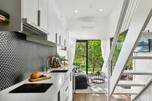 a kitchen with a staircase leading to a living room at 6SIXTEEN - Hot Tub or Cold Plunge, Infrared Sauna Launching March in Richmond