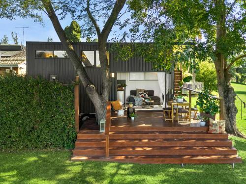 a backyard with a wooden deck with a tree at 6SIXTEEN - Hot Tub or Cold Plunge, Infrared Sauna Launching March in Richmond