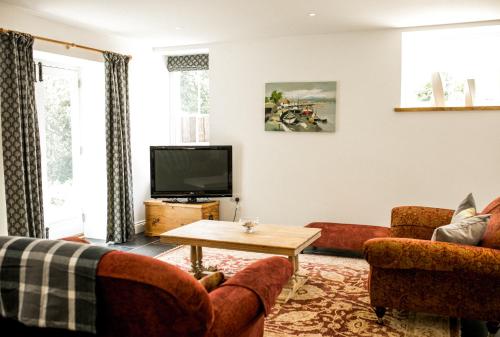 a living room with couches and a tv at Glynn Bull Pen in Bodmin