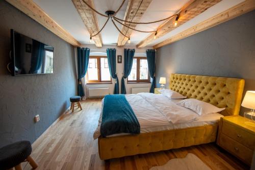 a bedroom with a large bed and blue curtains at Barrique Brâncoveanu 3 in Braşov