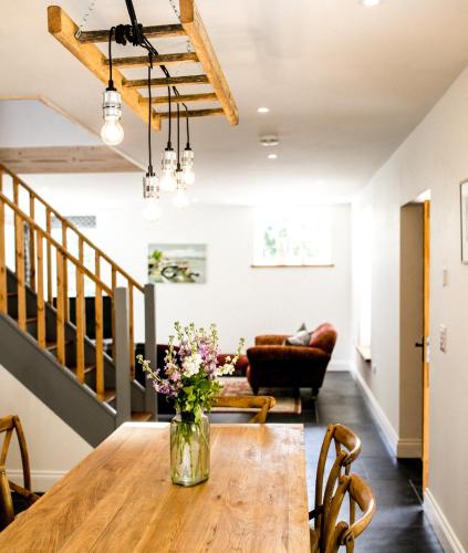 a dining room with a table with flowers on it at Glynn Bull Pen in Bodmin