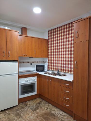 a kitchen with wooden cabinets and a white appliance at Cazorla LIVE in Cazorla