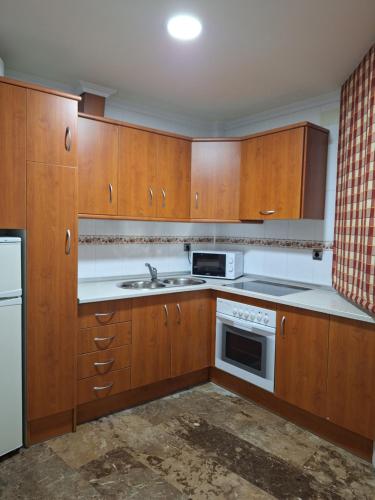 a kitchen with wooden cabinets and a sink at Cazorla LIVE in Cazorla