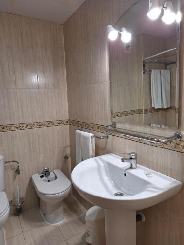 a bathroom with a sink and a toilet and a mirror at Cazorla LIVE in Cazorla