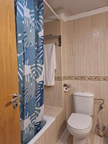 a bathroom with a toilet and a shower curtain at Cazorla LIVE in Cazorla