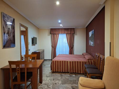 a bedroom with a bed and a table and a chair at Cazorla LIVE in Cazorla