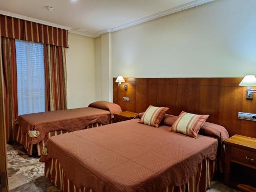 a hotel room with two beds and a window at Cazorla LIVE in Cazorla