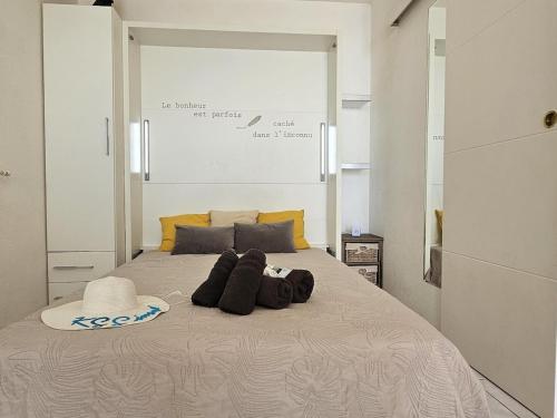 - un lit avec des oreillers et un chapeau dans l'établissement Vue mer - Studio - Parking - Wifi, à Saint-Raphaël