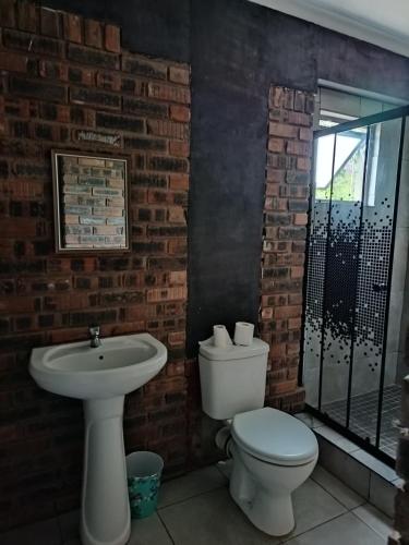 a bathroom with a white toilet and a sink at PMB Backpackers Lodge in Pietermaritzburg