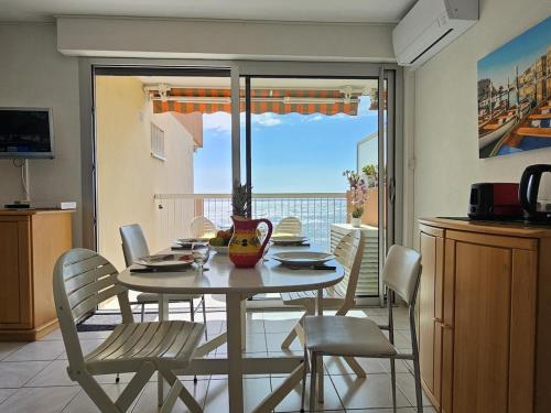 une salle à manger avec une table et des chaises et un balcon dans l'établissement Vue mer - Studio - Parking - Wifi, à Saint-Raphaël