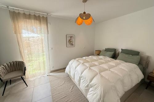 une chambre avec un grand lit blanc et une fenêtre dans l'établissement Cosy flat - Garden - Swimming pool, à Valbonne