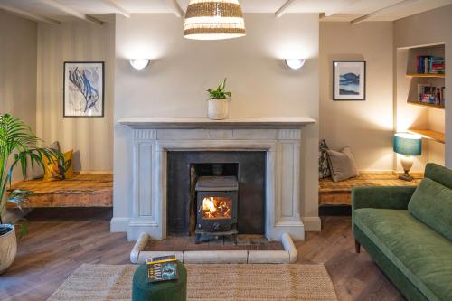 a living room with a fireplace and a green couch at Otter Hostel Connemara in Leenaun