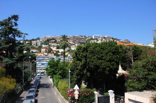 une rue de la ville avec des voitures garées sur le côté d'une colline dans l'établissement Explore Nice from our cozy & quiet 2BR aptparking, à Nice