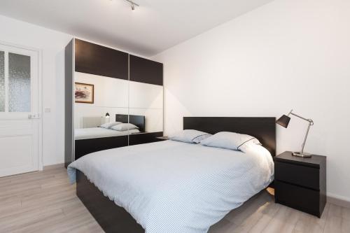 une chambre blanche avec un grand lit et un miroir dans l'établissement Explore Nice from our cozy & quiet 2BR aptparking, à Nice