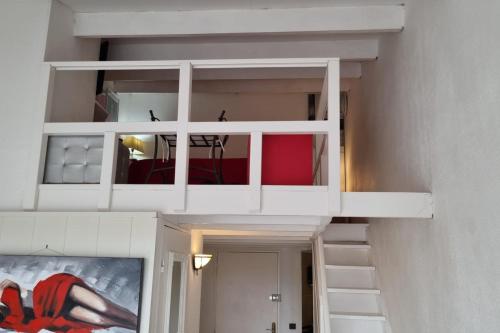 - un escalier dans une chambre avec des étagères blanches dans l'établissement Naturiste Cap d'Agde Port Soleil 589, au Cap d'Agde